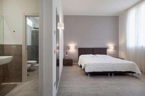 a white bedroom with a bed and a bathroom at Residence Le Querce in Monza