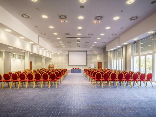 a conference room with red chairs and a screen at Ensana Sovata in Sovata