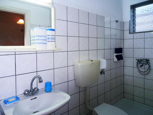 a bathroom with a sink and a toilet and a mirror at Malimi in Prinos