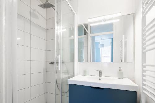 een witte badkamer met een wastafel en een douche bij Ty Paradis by Cocoonr in Rennes
