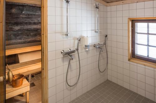 a shower in a bathroom with white tiles at Holiday Club Ruka Cottages in Oivanki
