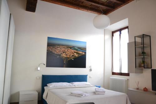una camera da letto con un letto e un dipinto sul muro di Casa degli Scacchi a Mantova