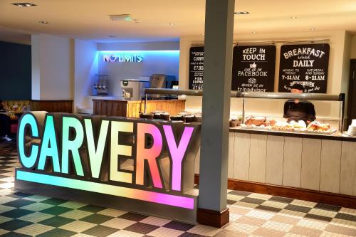 a restaurant with a carvery sign in front of a counter at Lock Keeper, Worksop by Marston's Inns in Worksop