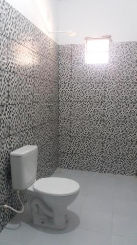 a bathroom with a white toilet in a room at Pousada da Mamae in Barra Grande