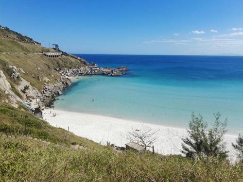 a view of a beach on a hill with the ocean at Morada do Mar Arraial do Cabo in Arraial do Cabo