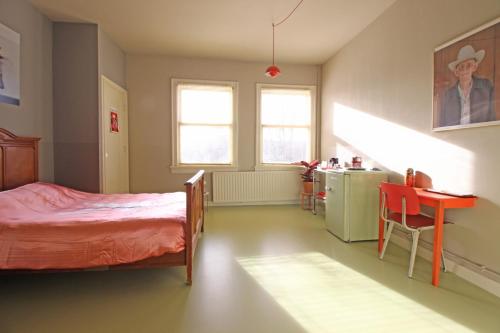 a bedroom with a bed and a table and a kitchen at Cafe Modern in Amsterdam