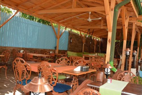 a restaurant with wooden tables and chairs and a wooden ceiling at Kaliptus Hotel in Kemer