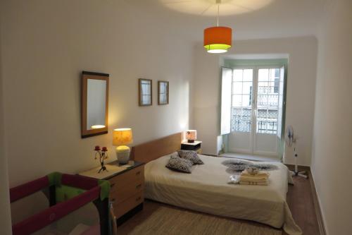 a bedroom with a bed and a window at Casa de Marvila in Santarém
