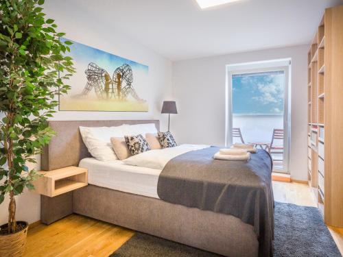 een slaapkamer met een bed en een groot raam bij SKY9 Penthouse Apartments in Wenen