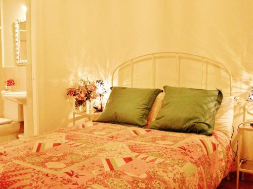 a bed with green pillows in a bedroom at Apartamento Centro Judería in Seville