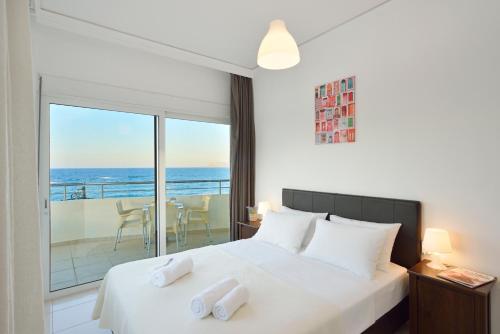 a bedroom with a bed with a view of the ocean at Kalamaki Apartments in Kalamaki Chanion