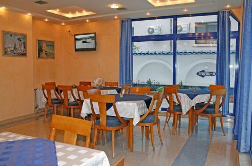 a restaurant with tables and chairs and a large window at Hotel Astoria in Burgas