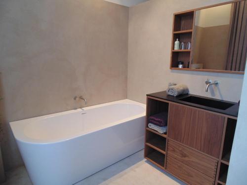 a bathroom with a bath tub and a sink at B&B De Gilleminus in Temse