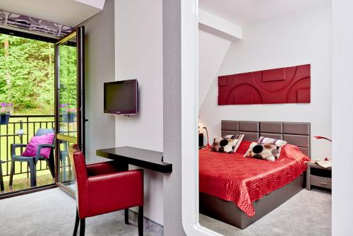 um quarto com uma cama vermelha e uma cadeira vermelha em Rezydencja Eger em Kazimierz Dolny
