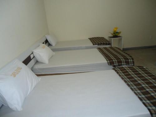 two beds in a small room with white walls at Hotel Portal Triunfo in Triunfo
