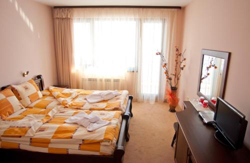 a bedroom with a bed in front of a window at Family hotel Iskar in Govedartsi