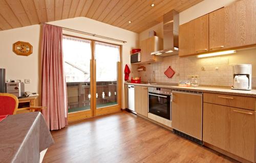 a large kitchen with wooden floors and a large window at Gästehaus Alpina in Bad Kohlgrub