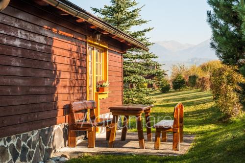 a wooden cabin with two chairs and a table at Aquamara Aquapark Tatralandia in Liptovský Mikuláš