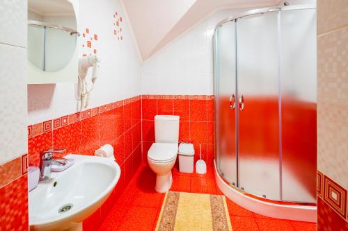 a bathroom with a toilet and a sink and a shower at Family Hotel Kaskad in Bukovel