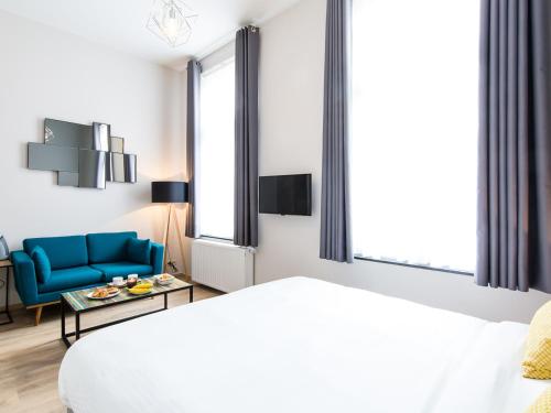 a bedroom with a bed and a blue couch at Urban Suites Brussels Schuman in Brussels