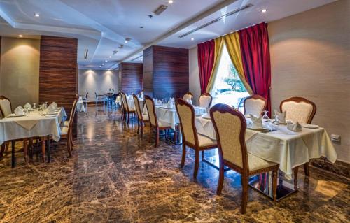 a restaurant with tables and chairs in a room at Executive Suites Abu Dhabi in Abu Dhabi