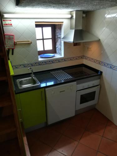 a small kitchen with a sink and a stove at Casa Lausus in Lousã