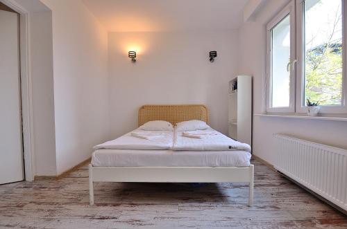 ソポトにあるVictus Apartamenty, Apartament La Figureの白いベッドルーム(窓付きのベッド付)