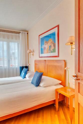 two beds with blue pillows in a hotel room at Hapimag Apartments Athens in Athens