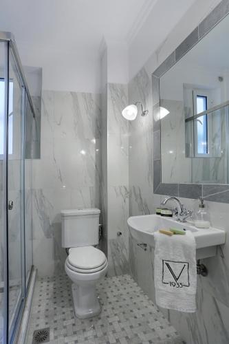 a bathroom with a toilet and a sink and a mirror at V1935 Luxurious Apartments in Athens