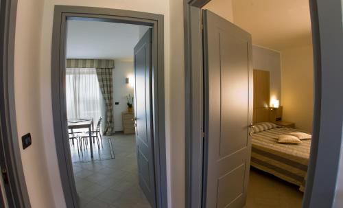 a door leading to a bedroom with a bed at Aregai Marina Hotel & Residence in Santo Stefano al Mare