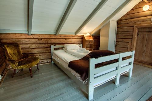 a bedroom with a white bed and a chair at Håholmen - by Classic Norway Hotels in Karvåg