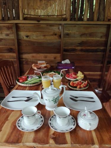 a table with cups and plates of food and drinks at Mount Wood Star in Ella