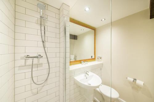 a bathroom with a shower and a toilet and a sink at The Fox House by Innkeeper's Collection in Hathersage