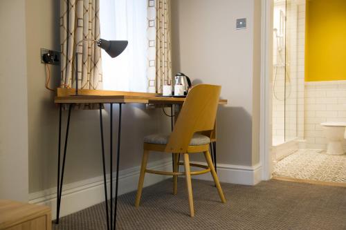a desk with a chair and a lamp in a room at The Fox House by Innkeeper's Collection in Hathersage
