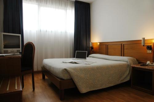 a bedroom with a bed with a laptop on it at Hotel Cavallino in Faenza