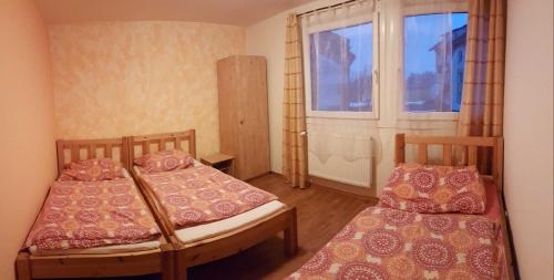 Habitación pequeña con 2 camas y ventana en Apartmány Mimpi, en Frymburk