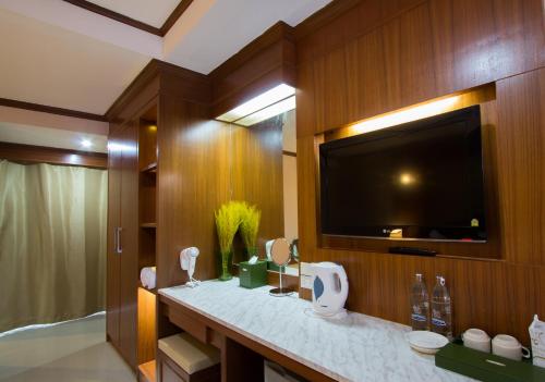 a bathroom with a flat screen tv and a sink at The Lion King Hotel Udonthani in Udon Thani