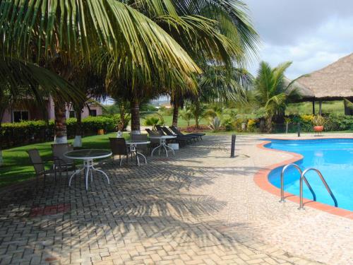 a patio with tables and chairs next to a swimming pool at Bojo Beach Resort in Bortianor