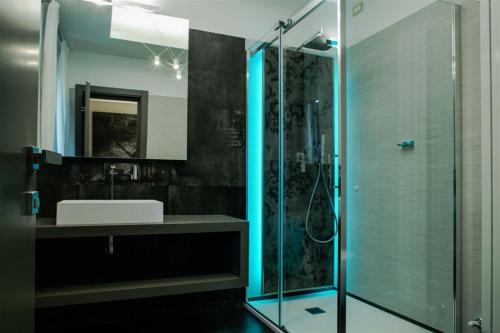 a bathroom with a sink and a glass shower at Via Veneto Luxury Suites in Rome