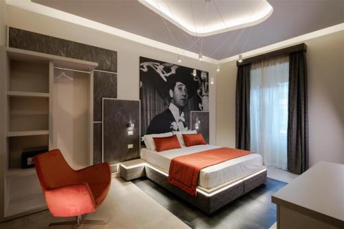 una camera con letto king-size e sedia rossa di Via Veneto Luxury Suites a Roma