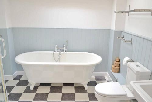ein Badezimmer mit einer weißen Badewanne und einem WC in der Unterkunft Hampton Wafre Cottage in Docklow