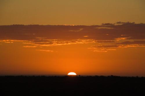 an orange sunset with the sun in the horizon at Vuyani Safari Lodge in Hoedspruit
