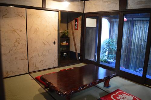 a living room with a wooden table and windows at YUMEJI Vintage Villa in Kyoto