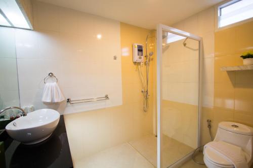 a bathroom with a shower and a toilet and a sink at The Lion King Hotel Udonthani in Udon Thani
