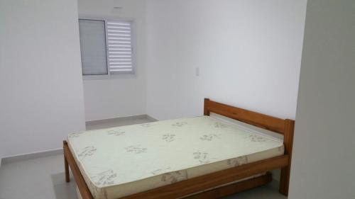 a small bed in a room with a window at Apartamento Aconchegante in Ubatuba