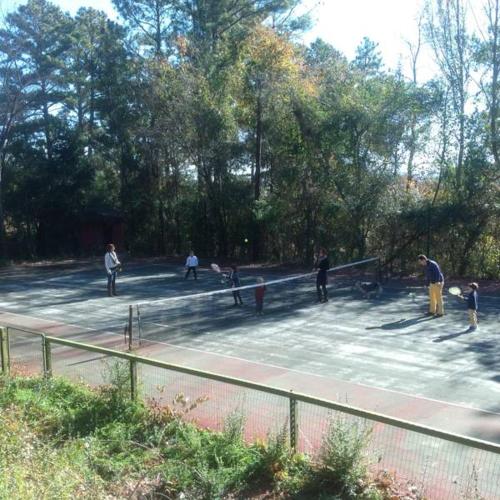 a group of people playing tennis on a tennis court at Springwood Inn in Anniston