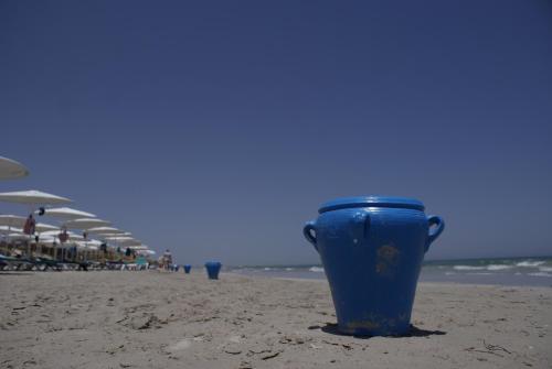 a blue cup sitting on the beach at El Mouradi Mahdia in Mahdia