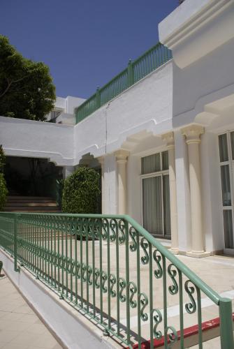 a green fence in front of a white house at El Mouradi Mahdia in Mahdia