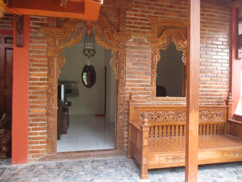 an entrance to a brick building with a wooden bench at Rumah Ukhi in Yogyakarta