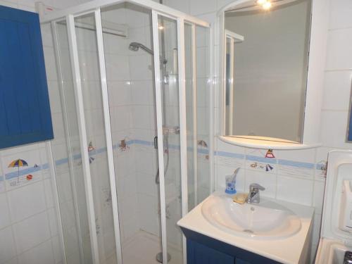 La salle de bains est pourvue d'une douche et d'un lavabo. dans l'établissement NICE FLAT 50M BEACH & CENTER, à Cabourg